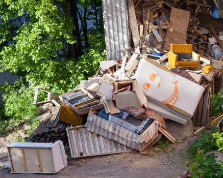 Operatives loading a skip with secure procedures and protective gear