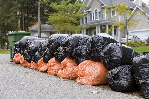 Recycling bins and sorting waste near a skip